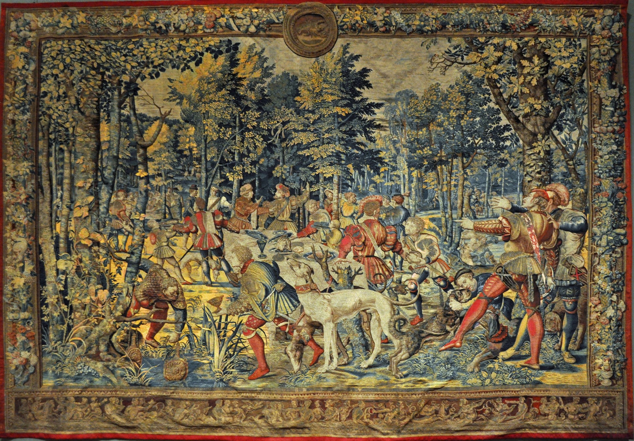 June tapestry from the Hunts of Maximilian, with court hunters, hounds, trees, and game in a deep woodland scene