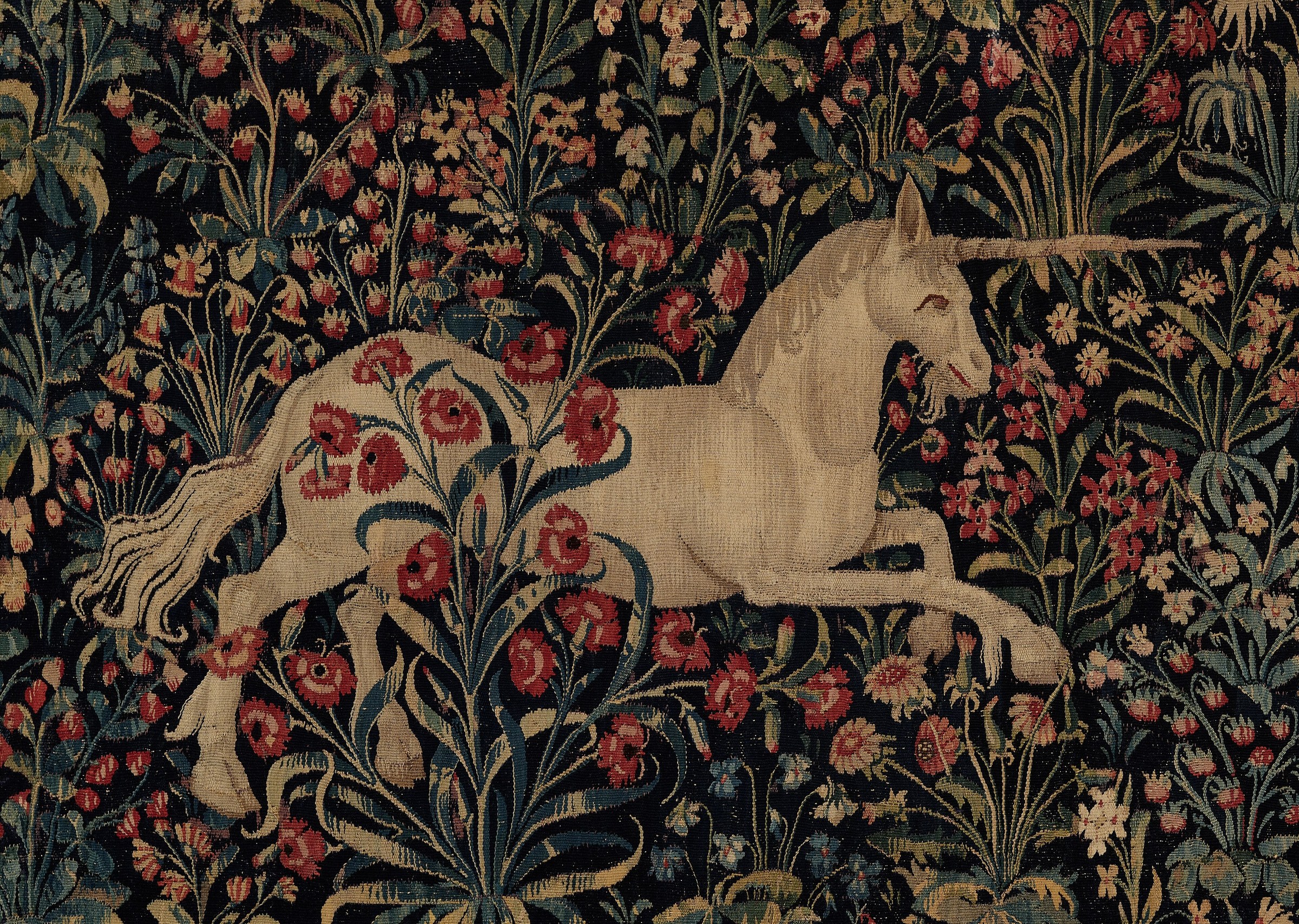 Late medieval tapestry with a unicorn, a stag, and a dense field of plants