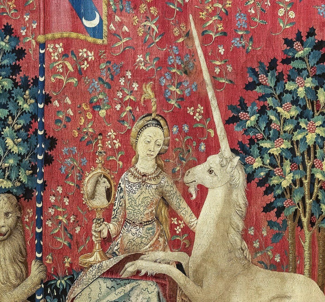 Editorial detail crop of the lady holding a mirror as the unicorn looks towards it